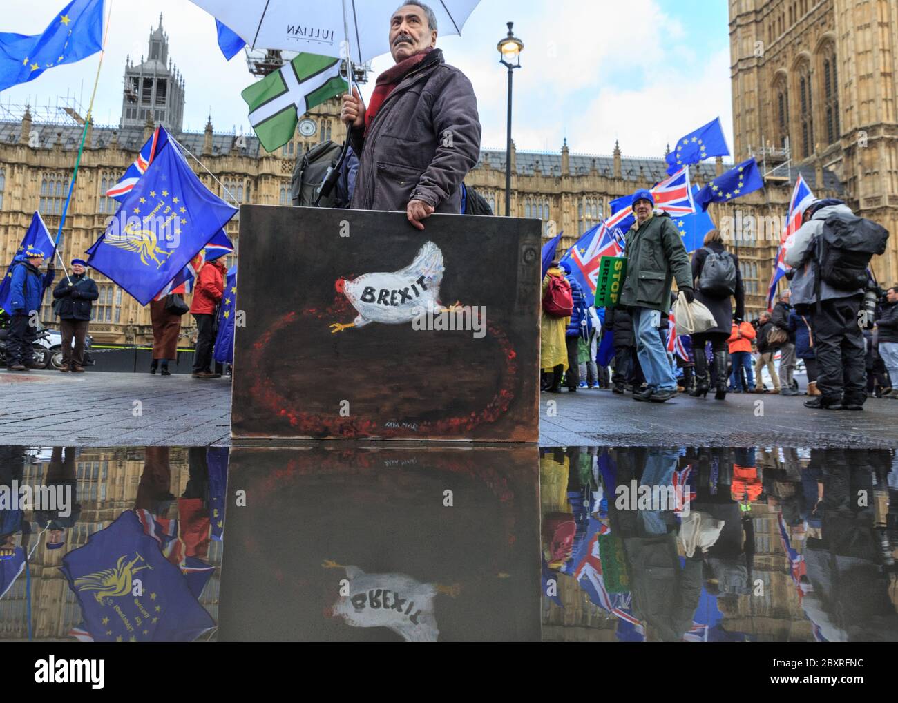 Artiste et peintre Kaya Mar avec l'une de ses peintures satiriques commentant le Brexit, hors des chambres du Parlement, Westminster Banque D'Images