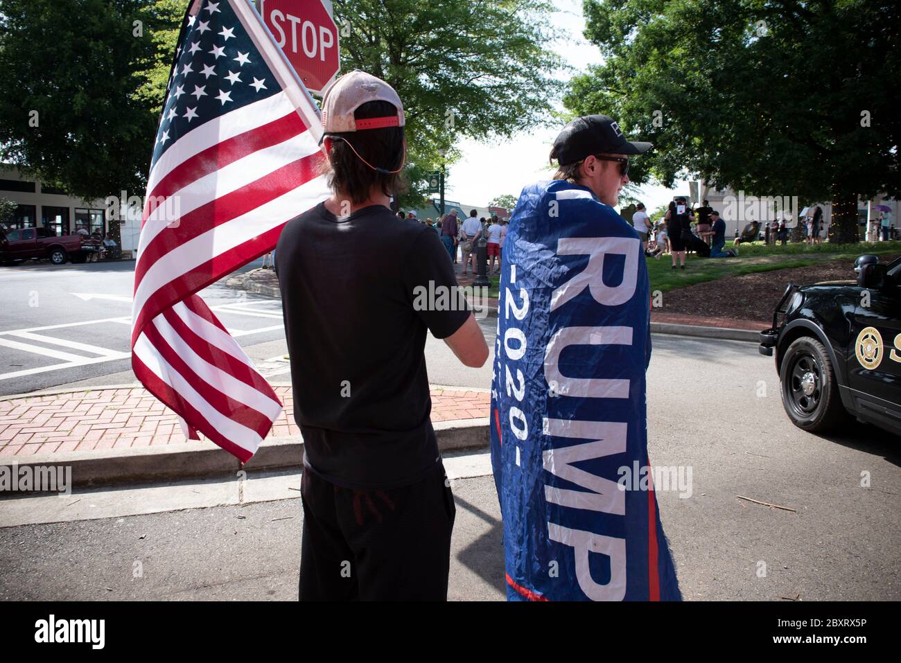 Jasper, Géorgie, États-Unis. 7 juin 2020. Les manifestants de Black Lives Matter se rassemblent à l'extérieur du palais de justice du comté de Pickens, dans la région rurale du nord de la Géorgie, pour protester contre la brutalité policière contre les minorités. Ils ont été accueillis par des contre-manifestants conservateurs et des partisans du président Trump qui ont assisté au rassemblement de l'autre côté de la rue principale de townÃs. Photo : les élèves du secondaire qui prévoient voter en novembre brandifient les drapeaux pour soutenir le président Trump alors que les voitures passent dans la rue principale de townÃs. Crédit : Robin Rayne/ZUMA Wire/Alay Live News Banque D'Images