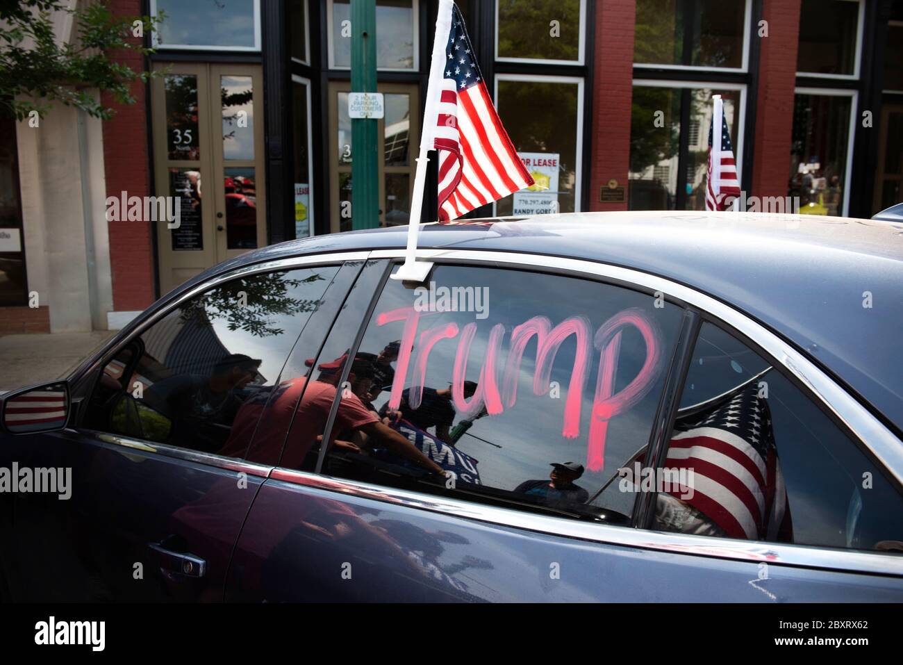 Jasper, Géorgie, États-Unis. 7 juin 2020. Les manifestants de Black Lives Matter se rassemblent à l'extérieur du palais de justice du comté de Pickens, dans la région rurale du nord de la Géorgie, pour protester contre la brutalité policière contre les minorités. Ils ont été accueillis par des contre-manifestants conservateurs et des partisans du président Trump qui ont assisté au rassemblement de l'autre côté de la rue principale de townÃs. Photo : les élèves du secondaire qui prévoient voter en novembre brandifient les drapeaux pour soutenir le président Trump alors que les voitures passent dans la rue principale de townÃs. Crédit : Robin Rayne/ZUMA Wire/Alay Live News Banque D'Images