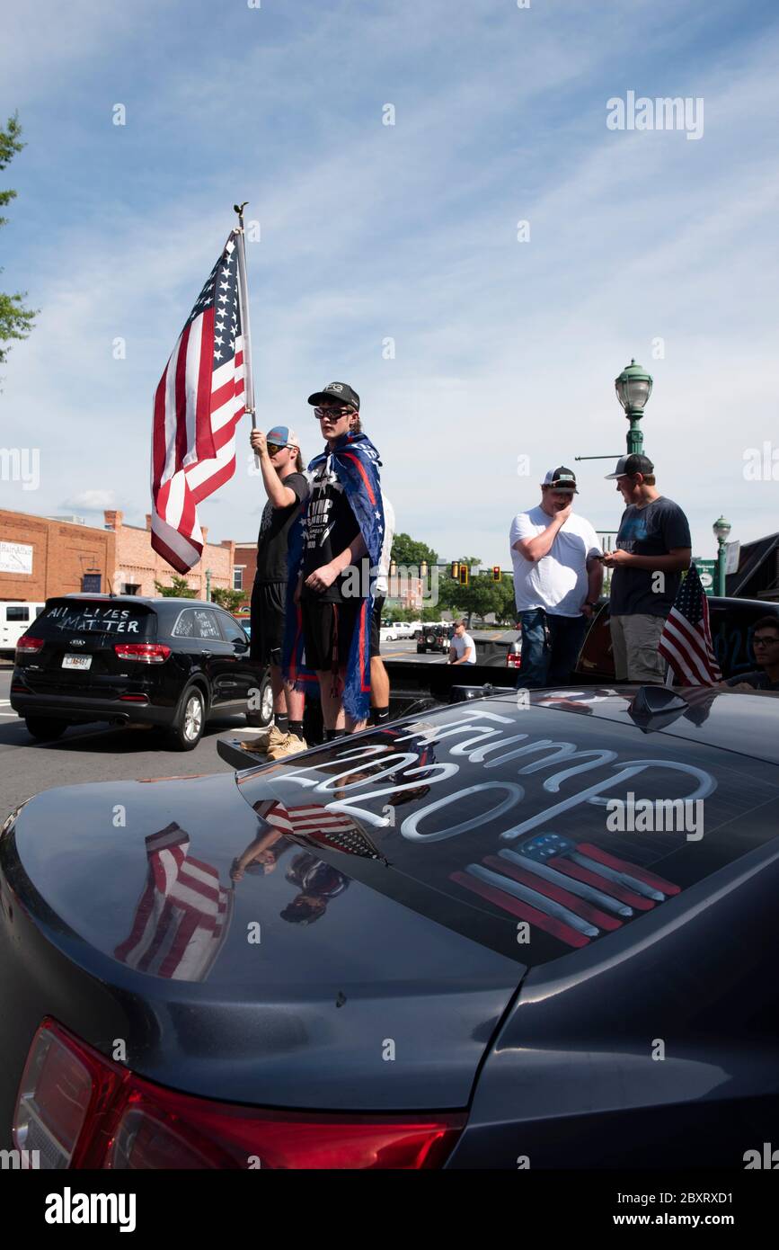 Jasper, Géorgie, États-Unis. 7 juin 2020. Les manifestants de Black Lives Matter se rassemblent à l'extérieur du palais de justice du comté de Pickens, dans la région rurale du nord de la Géorgie, pour protester contre la brutalité policière contre les minorités. Ils ont été accueillis par des contre-manifestants conservateurs et des partisans du président Trump qui ont assisté au rassemblement de l'autre côté de la rue principale de townÃs. Photo : les élèves du secondaire qui prévoient voter en novembre brandifient les drapeaux pour soutenir le président Trump alors que les voitures passent dans la rue principale de townÃs. Crédit : Robin Rayne/ZUMA Wire/Alay Live News Banque D'Images