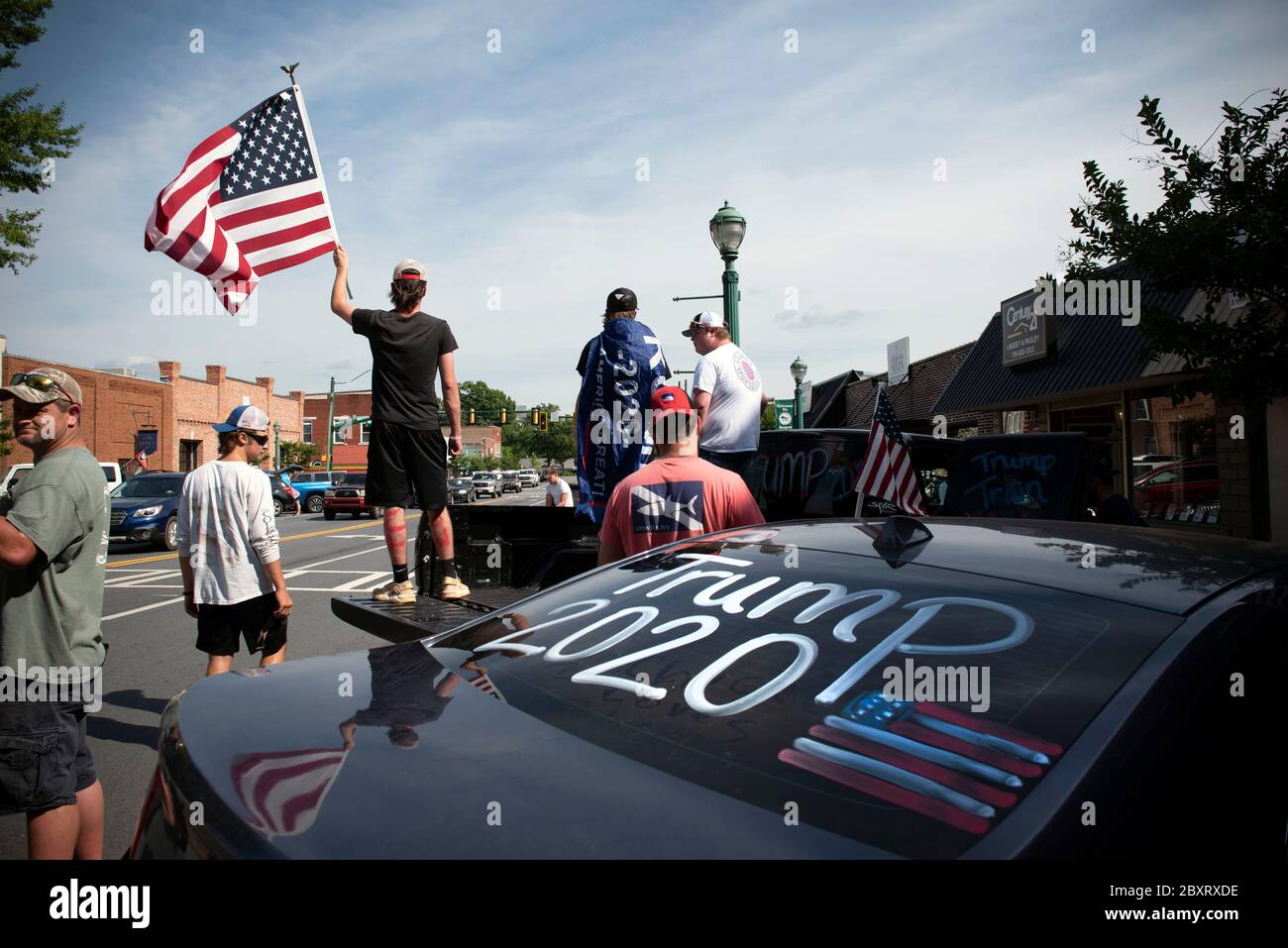 Jasper, Géorgie, États-Unis. 7 juin 2020. Les manifestants de Black Lives Matter se rassemblent à l'extérieur du palais de justice du comté de Pickens, dans la région rurale du nord de la Géorgie, pour protester contre la brutalité policière contre les minorités. Ils ont été accueillis par des contre-manifestants conservateurs et des partisans du président Trump qui ont assisté au rassemblement de l'autre côté de la rue principale de townÃs. Photo : les élèves du secondaire qui prévoient voter en novembre brandifient les drapeaux pour soutenir le président Trump alors que les voitures passent dans la rue principale de townÃs. Crédit : Robin Rayne/ZUMA Wire/Alay Live News Banque D'Images