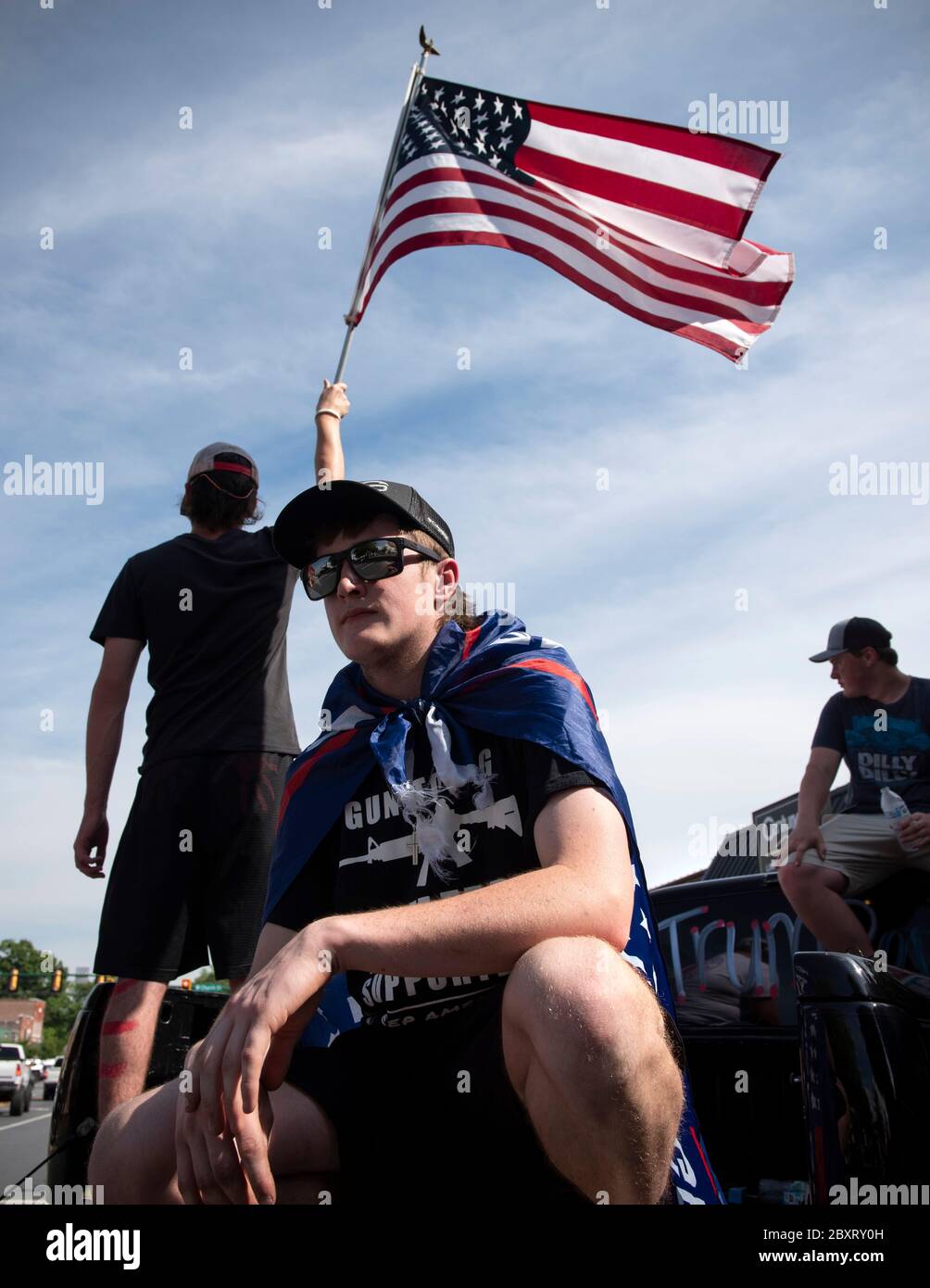 Jasper, Géorgie, États-Unis. 7 juin 2020. Les manifestants de Black Lives Matter se rassemblent à l'extérieur du palais de justice du comté de Pickens, dans la région rurale du nord de la Géorgie, pour protester contre la brutalité policière contre les minorités. Ils ont été accueillis par des contre-manifestants conservateurs et des partisans du président Trump qui ont assisté au rassemblement de l'autre côté de la rue principale de townÃs. Photo : les élèves du secondaire qui prévoient voter en novembre brandifient les drapeaux pour soutenir le président Trump alors que les voitures passent dans la rue principale de townÃs. Crédit : Robin Rayne/ZUMA Wire/Alay Live News Banque D'Images