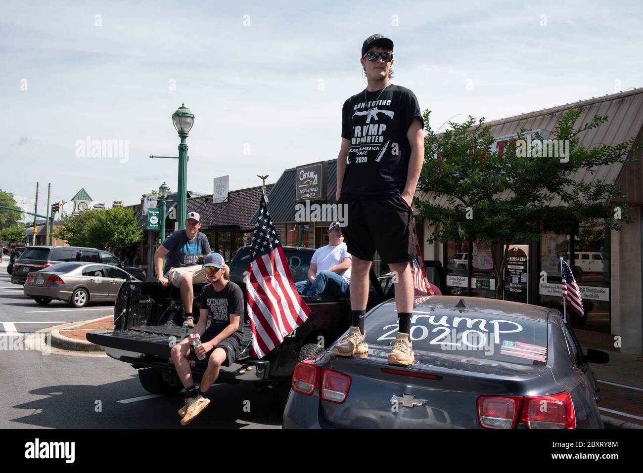 Jasper, Géorgie, États-Unis. 7 juin 2020. Les manifestants de Black Lives Matter se rassemblent à l'extérieur du palais de justice du comté de Pickens, dans la région rurale du nord de la Géorgie, pour protester contre la brutalité policière contre les minorités. Ils ont été accueillis par des contre-manifestants conservateurs et des partisans du président Trump qui ont assisté au rassemblement de l'autre côté de la rue principale de townÃs. Photo : les élèves du secondaire qui prévoient voter en novembre brandifient les drapeaux pour soutenir le président Trump alors que les voitures passent dans la rue principale de townÃs. Crédit : Robin Rayne/ZUMA Wire/Alay Live News Banque D'Images