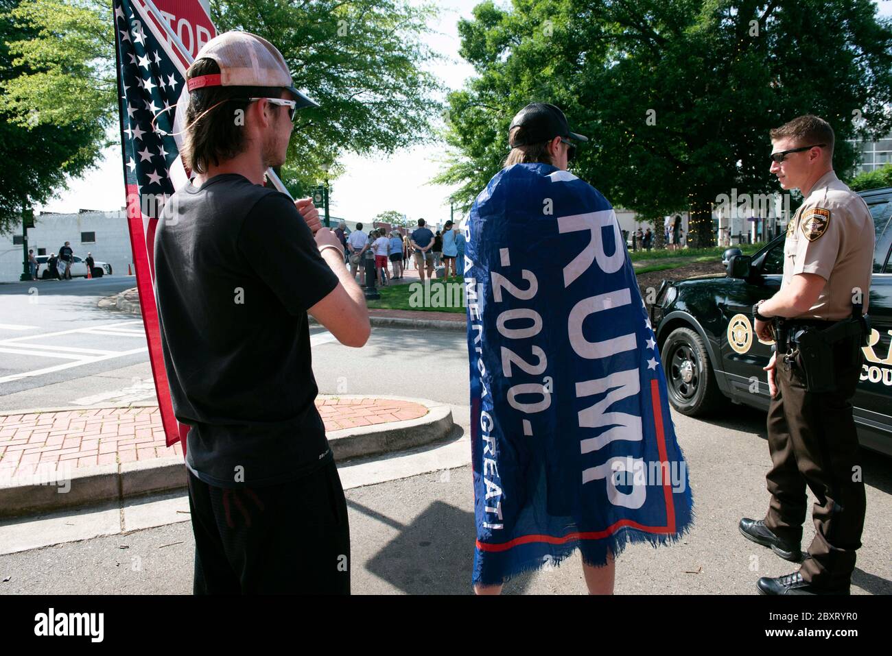 Jasper, Géorgie, États-Unis. 7 juin 2020. Les manifestants de Black Lives Matter se rassemblent à l'extérieur du palais de justice du comté de Pickens, dans la région rurale du nord de la Géorgie, pour protester contre la brutalité policière contre les minorités. Ils ont été accueillis par des contre-manifestants conservateurs et des partisans du président Trump qui ont assisté au rassemblement de l'autre côté de la rue principale de townÃs. Photo : les élèves du secondaire qui prévoient voter en novembre brandifient les drapeaux pour soutenir le président Trump alors que les voitures passent dans la rue principale de townÃs. Crédit : Robin Rayne/ZUMA Wire/Alay Live News Banque D'Images