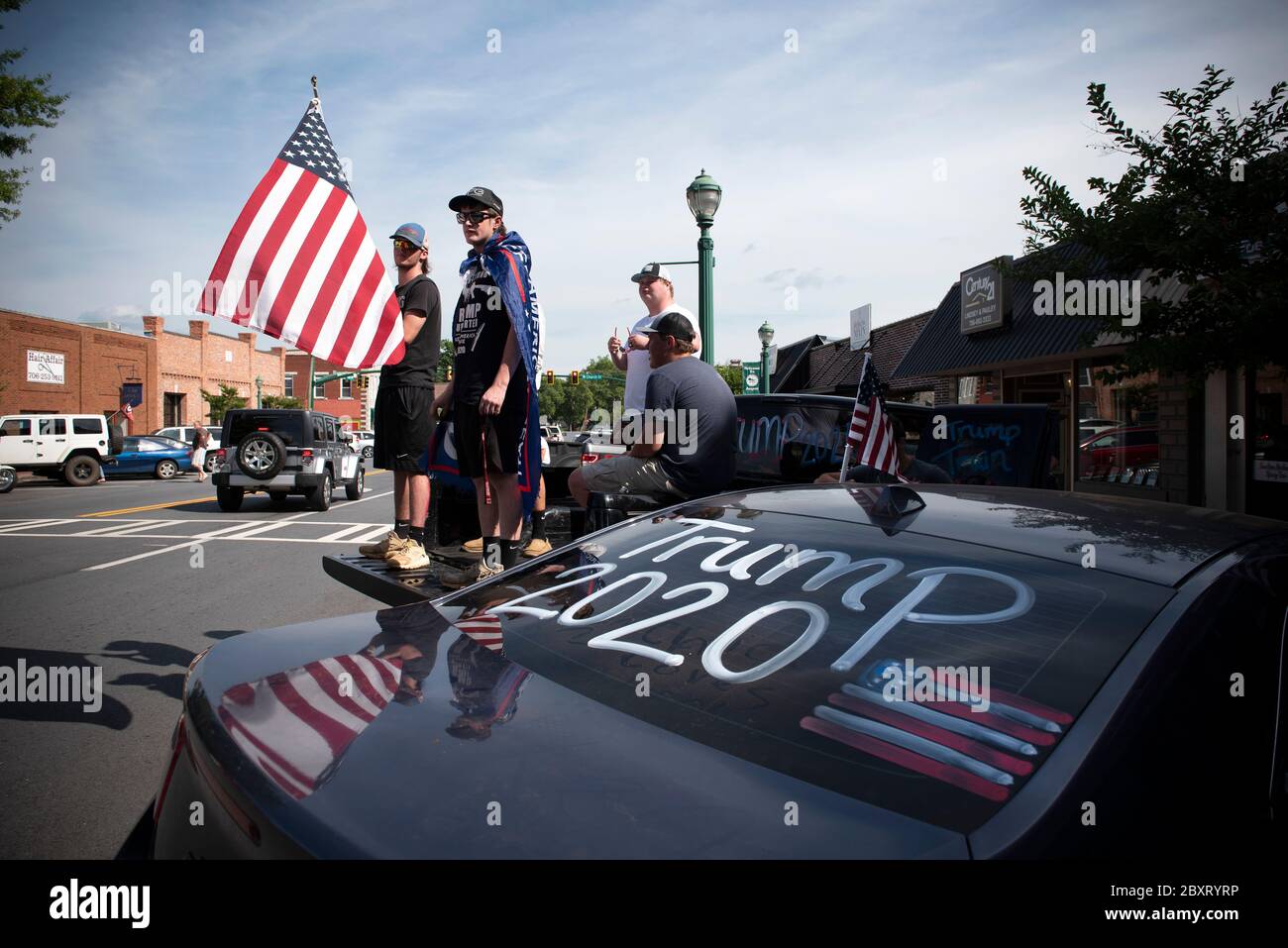 Jasper, Géorgie, États-Unis. 7 juin 2020. Les manifestants de Black Lives Matter se rassemblent à l'extérieur du palais de justice du comté de Pickens, dans la région rurale du nord de la Géorgie, pour protester contre la brutalité policière contre les minorités. Ils ont été accueillis par des contre-manifestants conservateurs et des partisans du président Trump qui ont assisté au rassemblement de l'autre côté de la rue principale de townÃs. Photo : les élèves du secondaire qui prévoient voter en novembre brandifient les drapeaux pour soutenir le président Trump alors que les voitures passent dans la rue principale de townÃs. Crédit : Robin Rayne/ZUMA Wire/Alay Live News Banque D'Images
