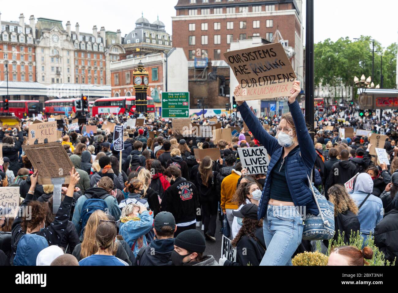 Une femme blanche se tient au-dessus d'une foule et tient un panneau à la manifestation Black Lives Matters à Victoria, Londres, le 6 juin 2020 Banque D'Images