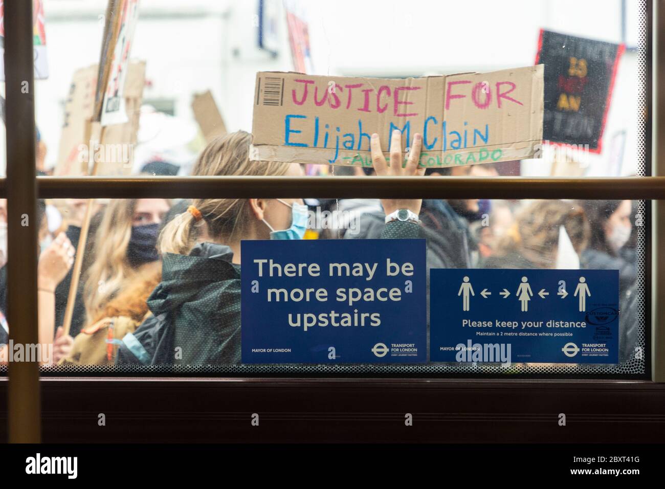 Signes sociaux de distanciation sur une fenêtre de bus avec une foule marchant derrière, Black Lives Matters manifestation sur Vauxhall Bridge Road, Londres, 6 juin 2020 Banque D'Images