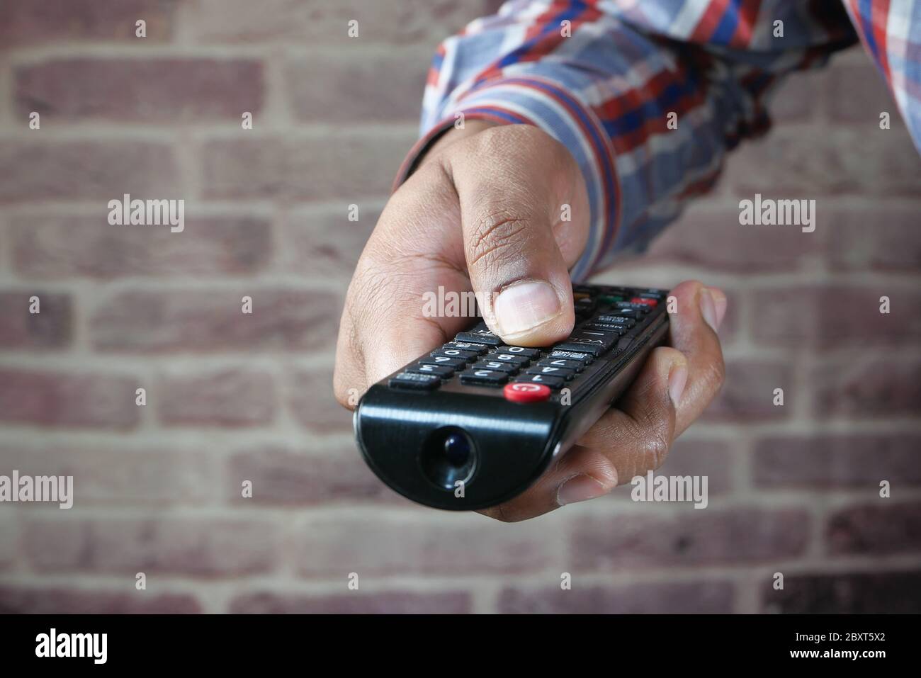 gros plan sur un homme tenant la télécommande du téléviseur. Banque D'Images