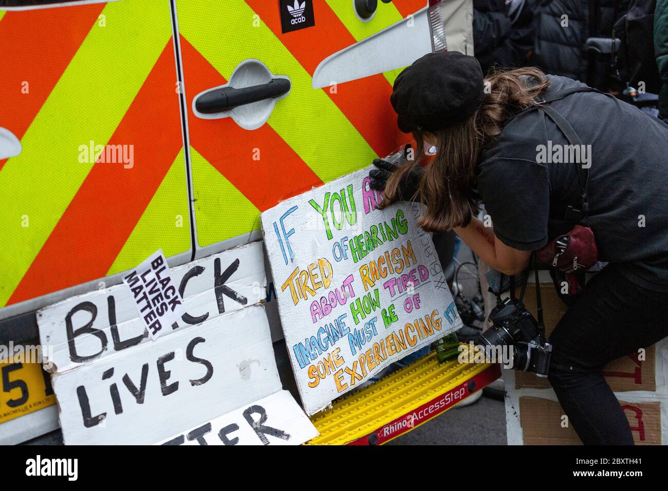 Un manifestant colle des signes à l'arrière d'une fourgonnette de police pendant la manifestation Black Lives Matters à Londres, le 6 juin 2020 Banque D'Images