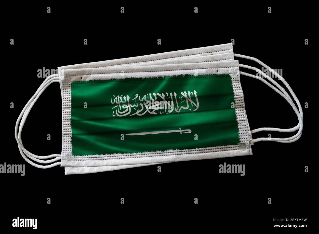 Masques chirurgicaux avec drapeau de l'Arabie Saoudite imprimé. Isolé sur fond noir. Concept de l'utilisation du masque dans l'effort saoudien de lutte contre Covid-19 Banque D'Images Masques chirurgicaux avec drapeau de l'Arabie Saoudite imprimé. Isolé sur fond noir. Concept de l'utilisation du masque dans l'effort saoudien de lutte contre Covid-19 Banque D'Images