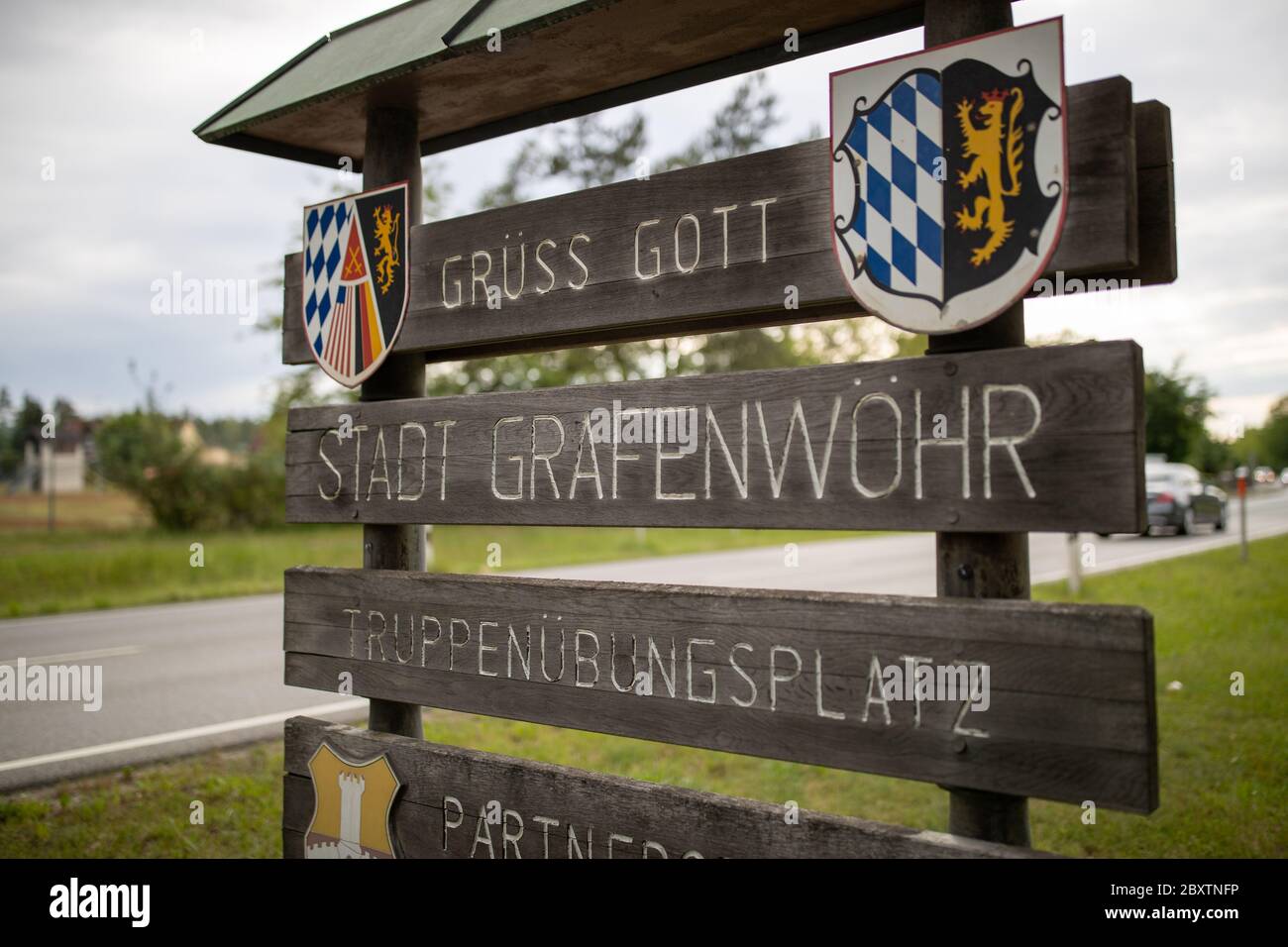 08 juin 2020, Bavière, Grafenwöhr: 'Grüss Gott - Stadt Grafenwöhr - Truppenübungsplatz' est écrit sur un panneau en bois. Actuellement, les forces américaines ont encore environ 34,500 soldats stationnés en Allemagne, dont environ 9,500, selon les chiffres américains, se trouvent sur les sites de Grafenwöhr et Vilseck dans le Haut-Palatinat. Photo: Daniel Karmann/dpa Banque D'Images