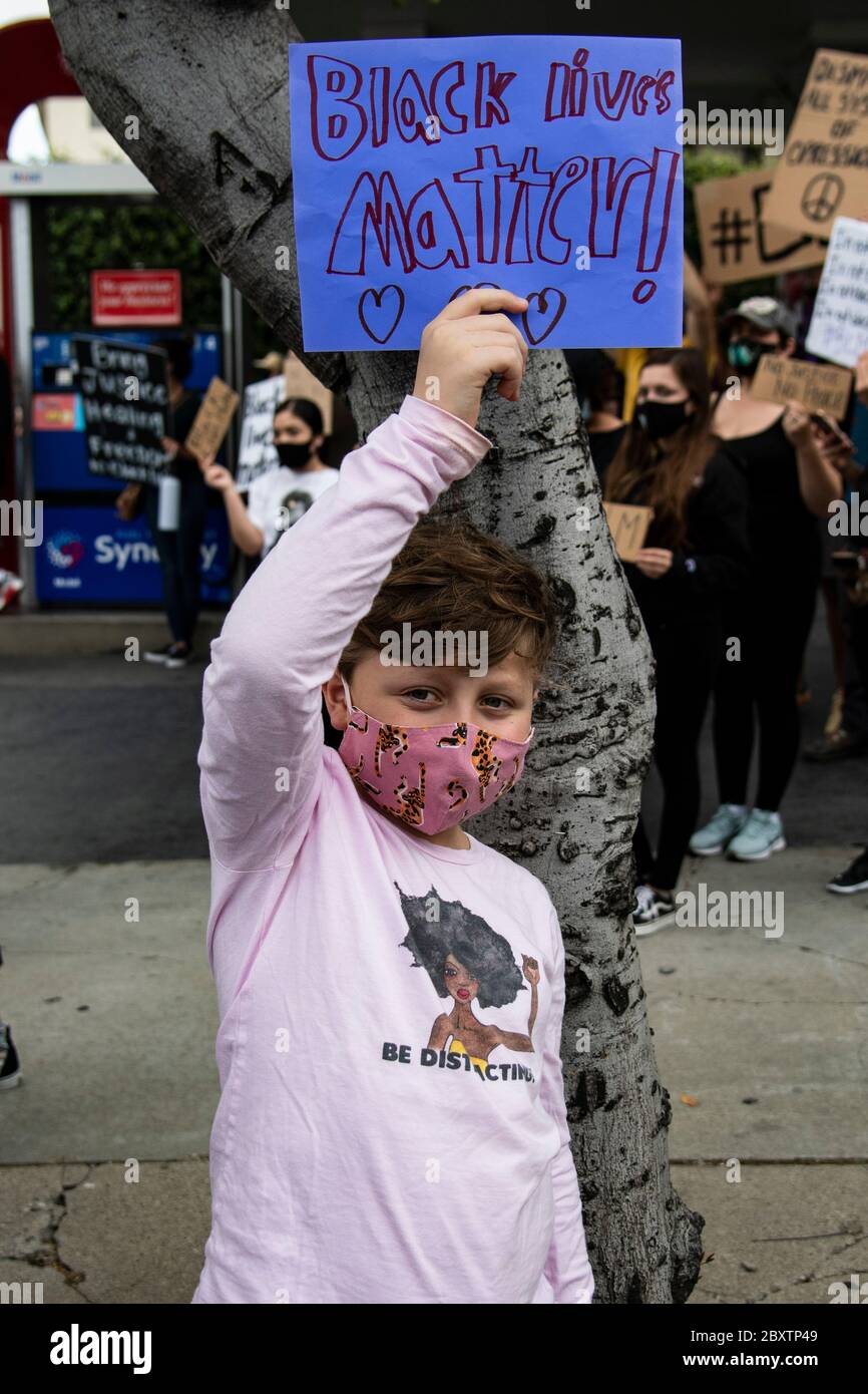 Des jeunes garçons proteste avec un signe à la manifestation en hommage à George Floyd, dans le quartier Highland Park de Los Angeles, Californie Banque D'Images