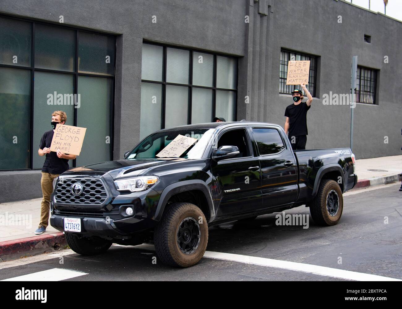 Deux jeunes hommes blancs portent des signes de protestation lors d'une manifestation de George Floyd à Los Angeles, CA Banque D'Images