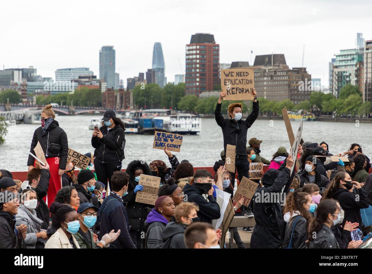 Des manifestants tenant des panneaux se tiennent sur le pont Vauxhall pendant la manifestation Black Lives Matters à Londres, le 6 juin 2020 Banque D'Images