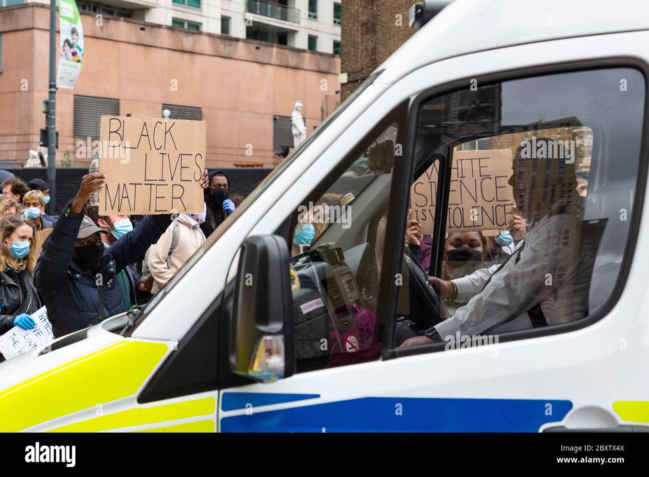 De jeunes manifestants noirs ont mis des signes à la fenêtre d'une fourgonnette de police lors de la manifestation Black Lives Matters à Londres, le 6 juin 2020 Banque D'Images