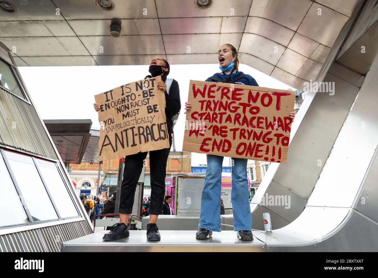 Une fille blanche et une fille ethnique tenant des signes et criant pendant la Black Lives Matters proteste à Vauxhall, Londres, 6 juin 2020 Banque D'Images