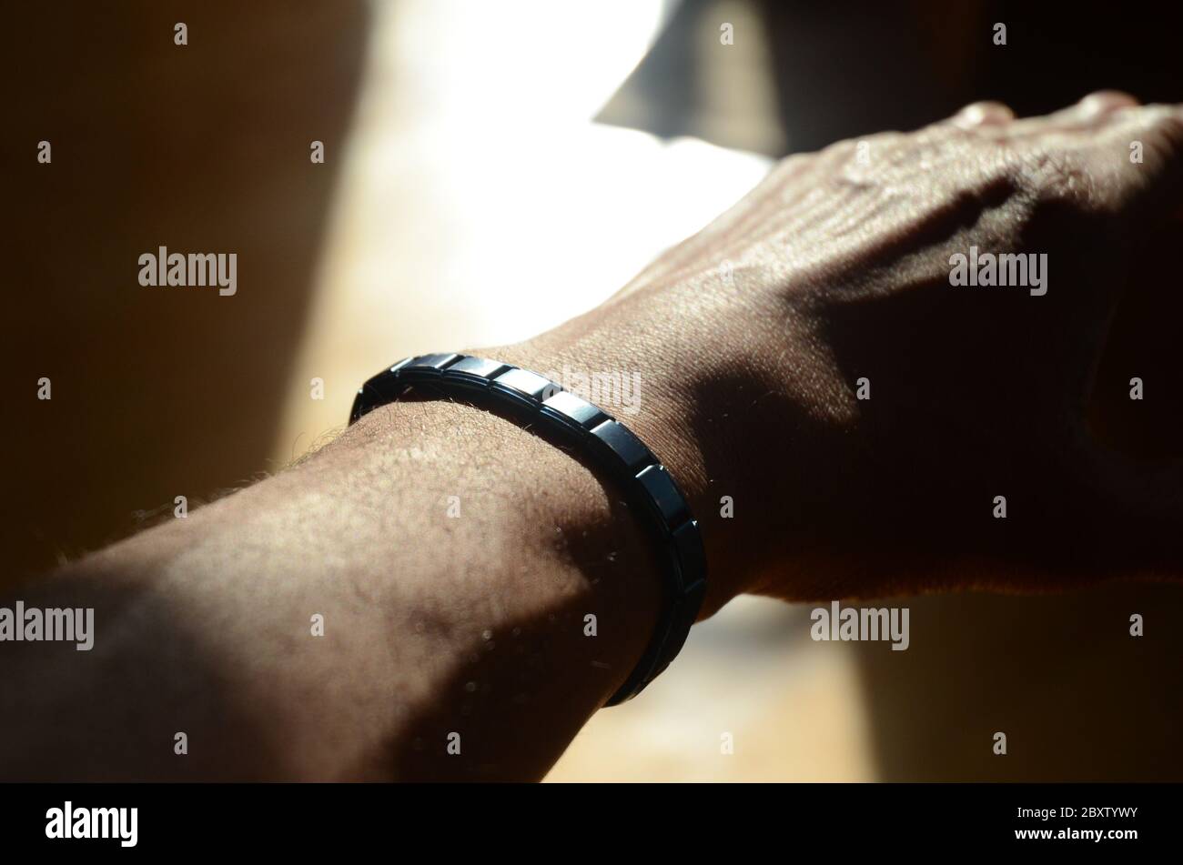 DÉPLACEMENT POLAIRE : un homme exerce son poignet à l'aide d'un bracelet magnétique contenant des pierres tourmaline pour augmenter la force. Banque D'Images
