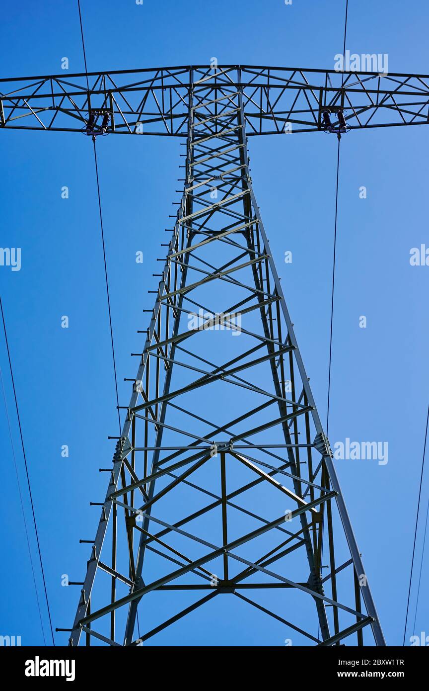 Photo à angle bas d'en dessous jusqu'au sommet d'un pylône électrique contre le ciel bleu. Banque D'Images