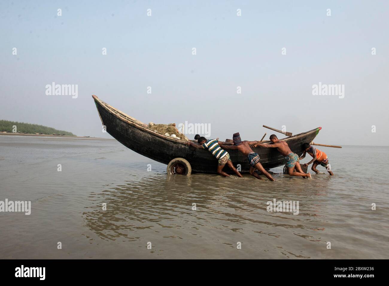 Les pêcheurs reviennent de la mer avec des poissons et ils essaient de garder leur bateau en sécurité en dehors de la plage de mer. Banque D'Images