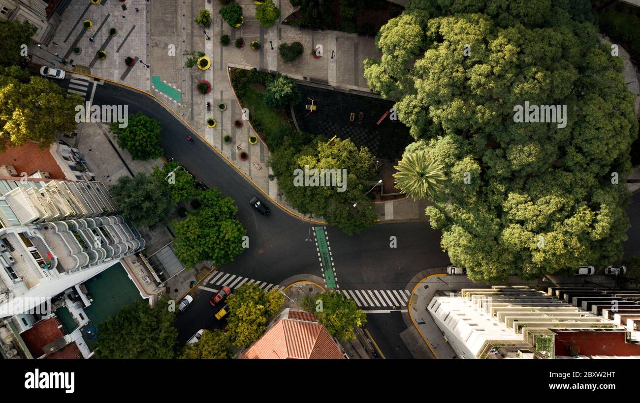 Vue aérienne de haut en bas sur la place avec des espaces verts, des arbres, des terrains de jeux et des appartements résidentiels autour de lui. Banque D'Images