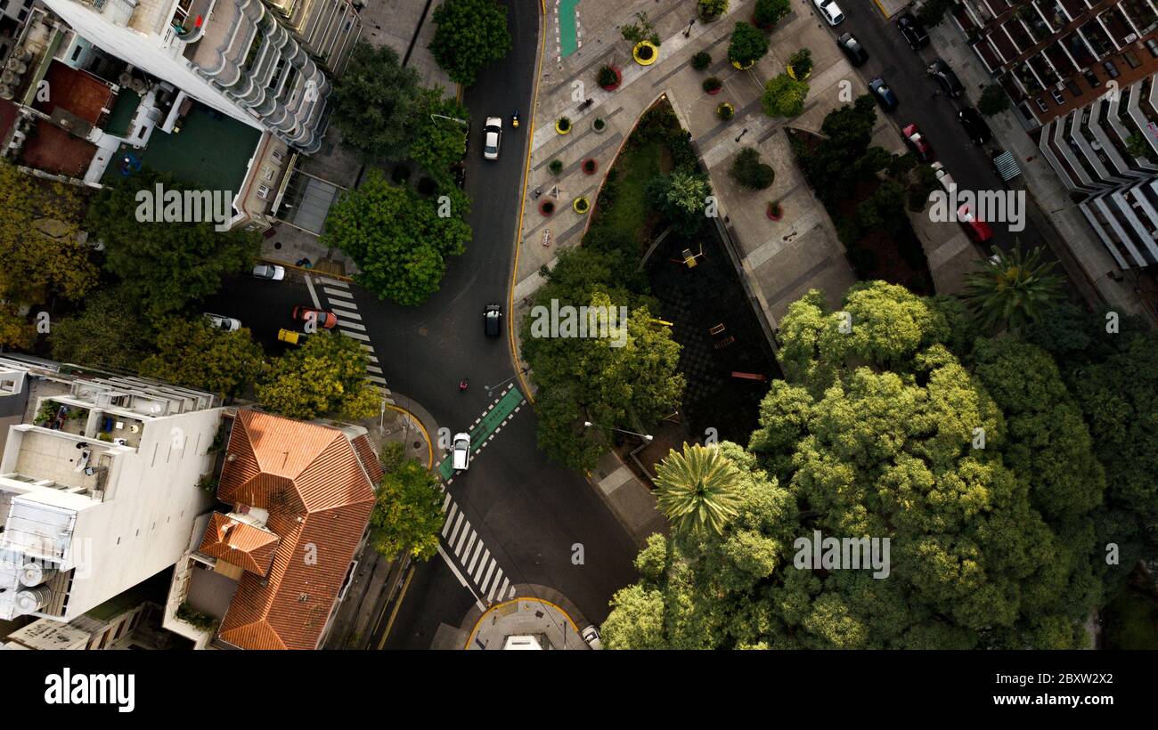 Vue aérienne de haut en bas sur la place avec des espaces verts, des arbres, des terrains de jeux et des appartements autour. Banque D'Images