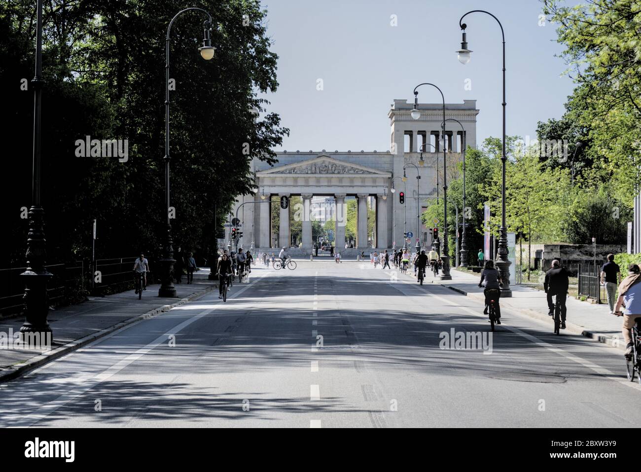 Porte de la ville de Propylaea à l'ouest de Königsplatz à Munich, en Allemagne, avec des cyclistes le long de la route Banque D'Images