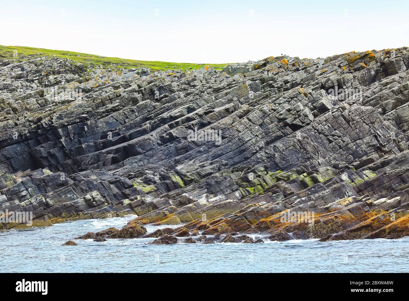 Côte rocheuse de l'île, avec vagues de l'océan éclaboussant, île de Mousa, Shetland, Écosse. Banque D'Images