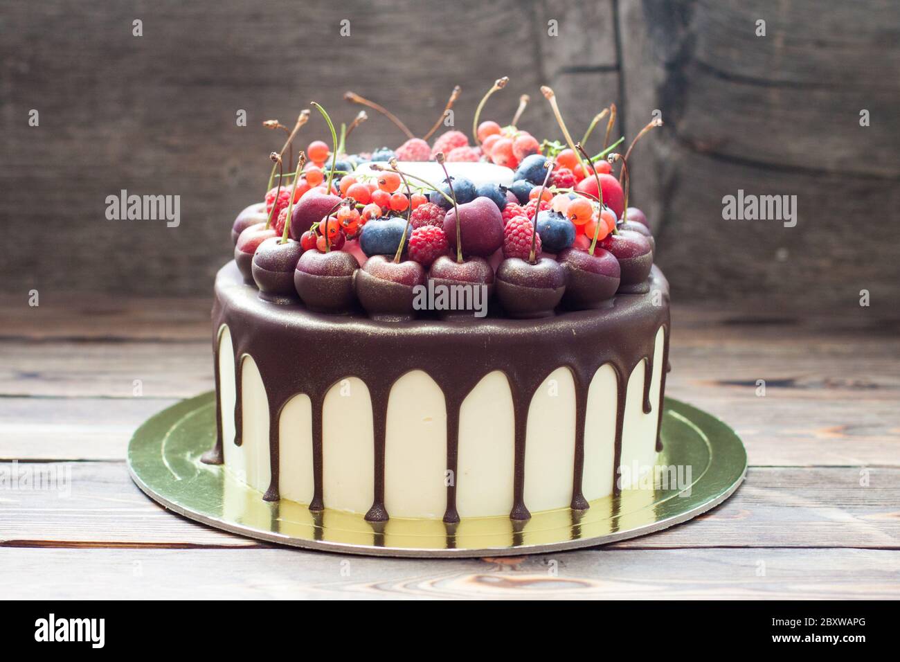 Gateau D Anniversaire Avec Chocolat Fondu Cerise Fraiche Framboise Fraise Cassis Myrtille Sur Fond De Bois Rustique Photo Stock Alamy