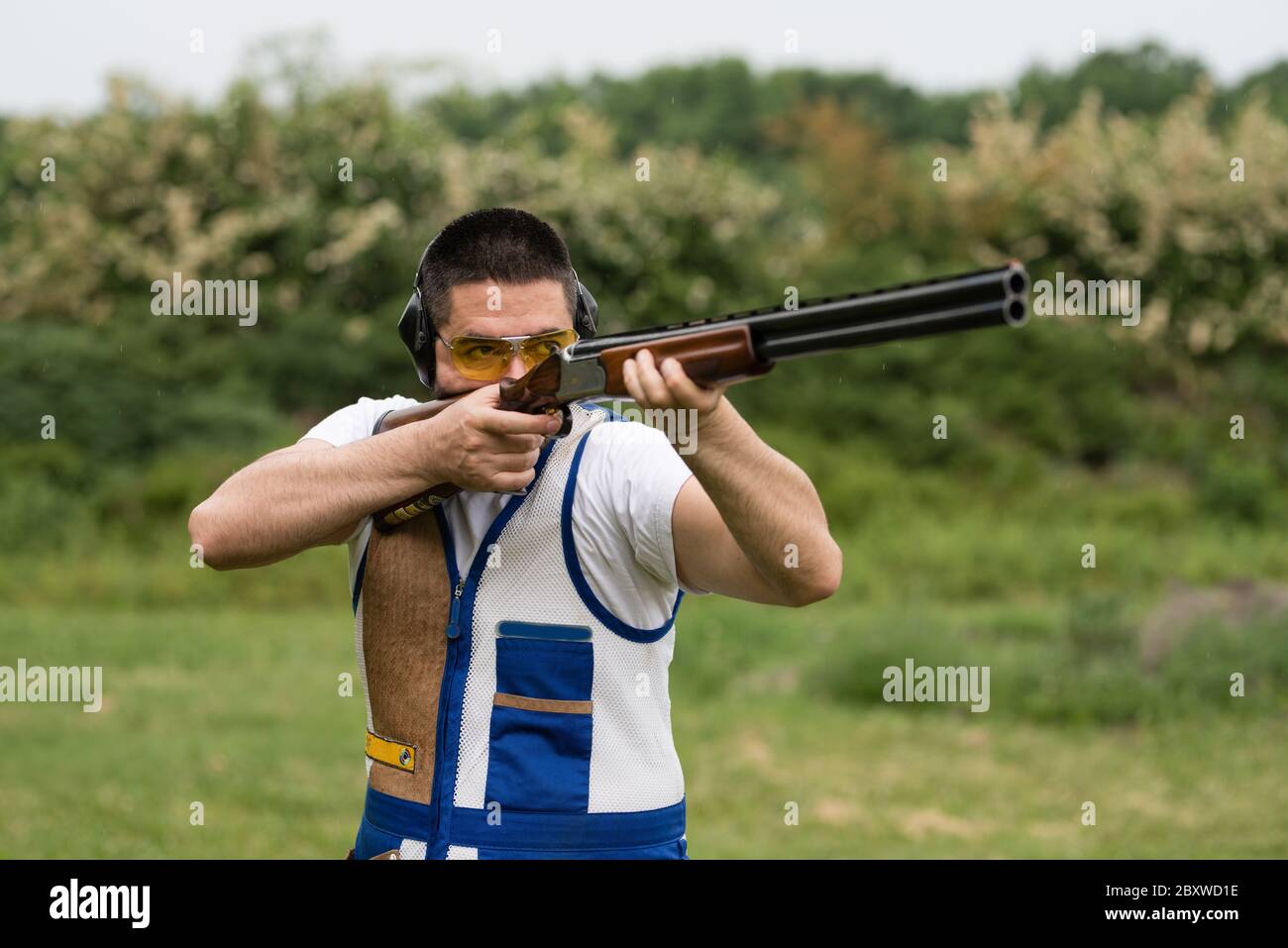 Homme de tir skeet avec un fusil de chasse. Banque D'Images