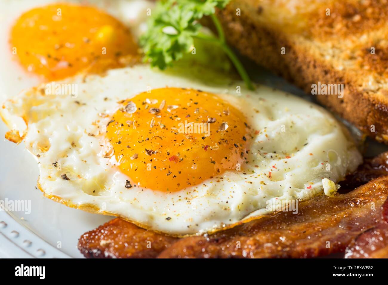Œufs de Sunnyside faits maison petit-déjeuner avec pain grillé et bacon Banque D'Images