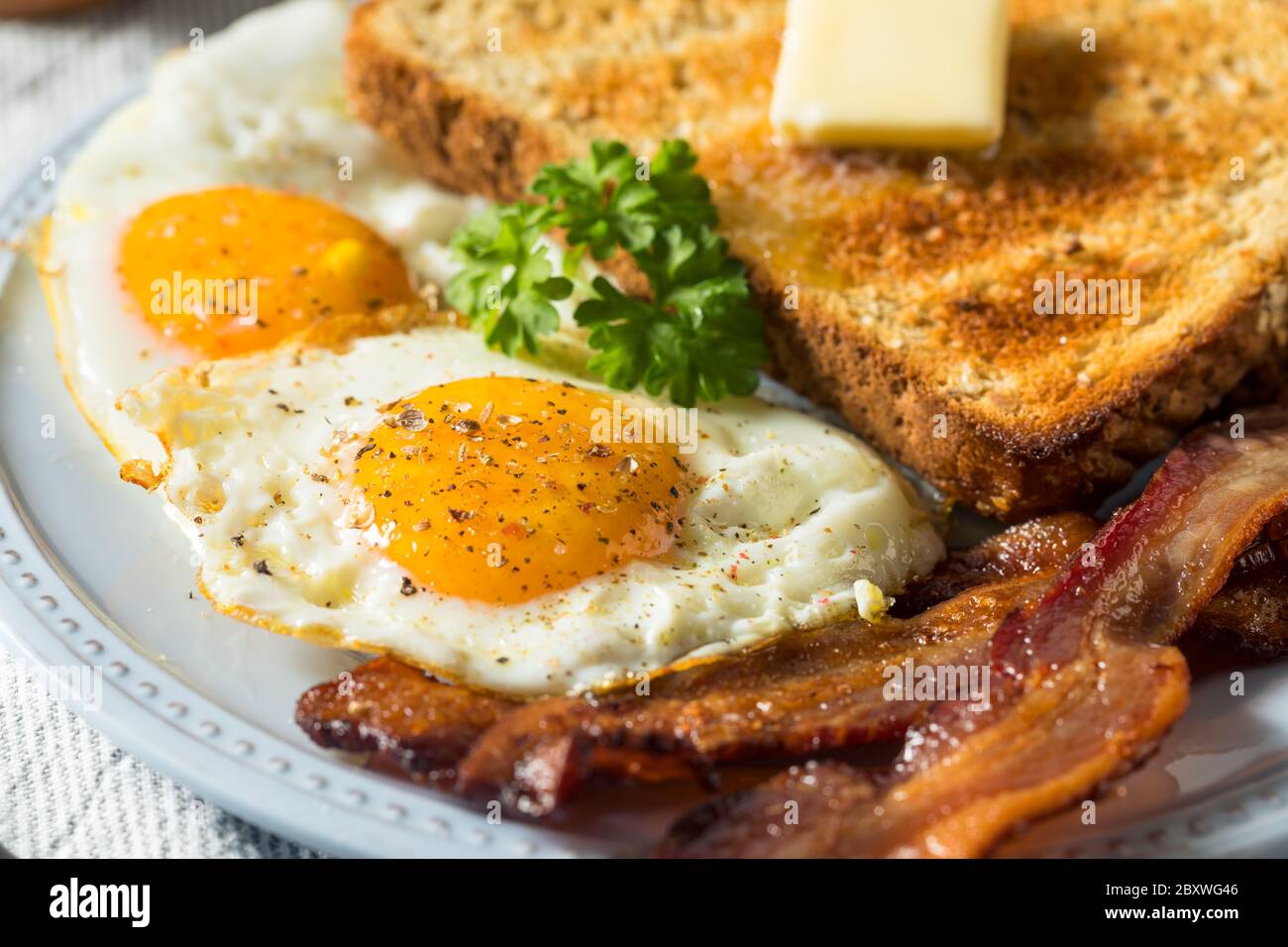 Œufs de Sunnyside faits maison petit-déjeuner avec pain grillé et bacon Banque D'Images