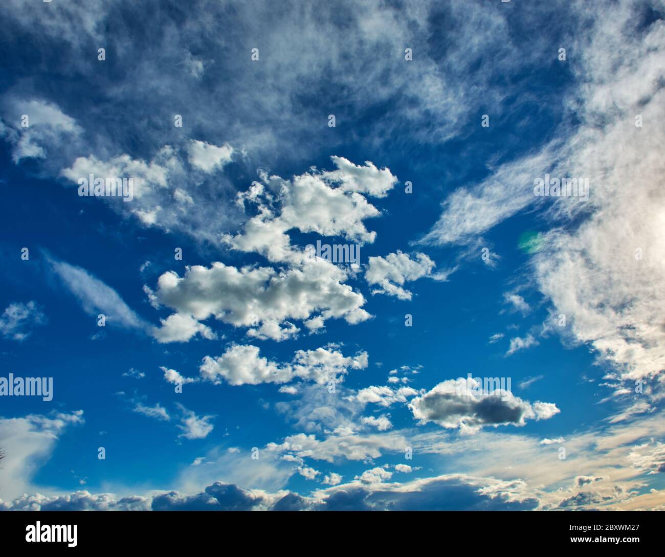 Un magnifique ciel bleu avec des formes variées et fantaisistes de nuages blancs Banque D'Images