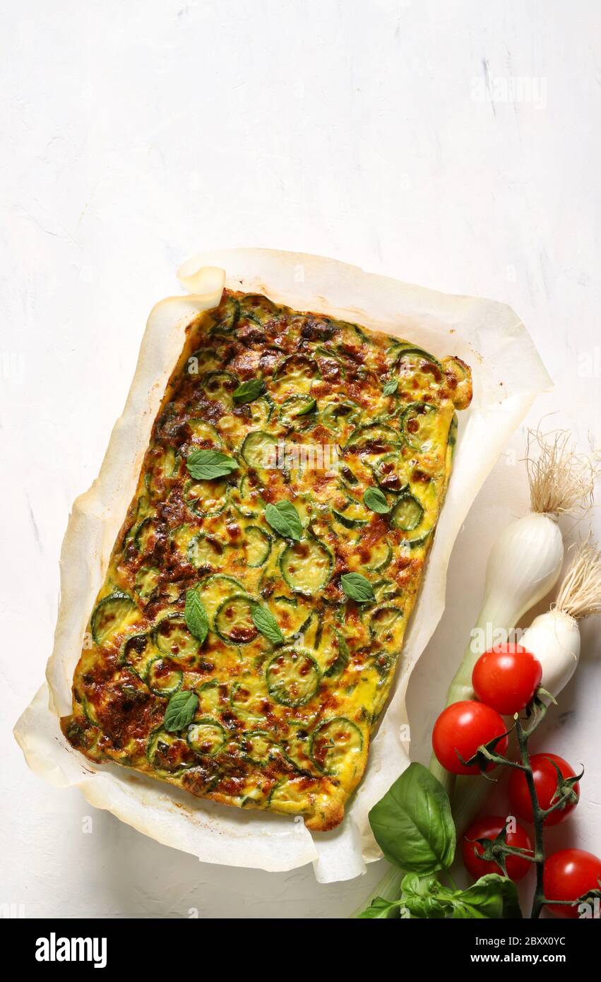 Concept alimentaire. Omelette cuite au four avec courgettes, poireaux et fromage isolés sur fond blanc. Vue de dessus. Banque D'Images