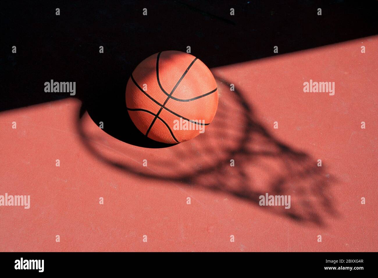 Un terrain de basket-ball et net sur une cour de l'ombre rouge Photo Stock  - Alamy