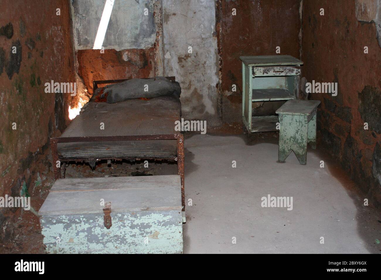 Une ancienne cellule de prison avec lit et bureau Banque D'Images