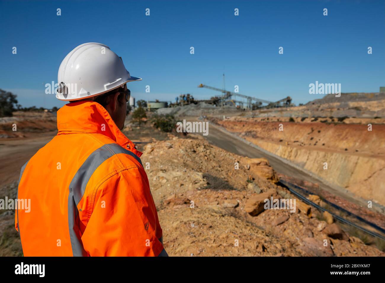 Mineur non identifiable devant une route portique de mine de cuivre, minehead en arrière-plan en Nouvelle-Galles du Sud en Australie Banque D'Images