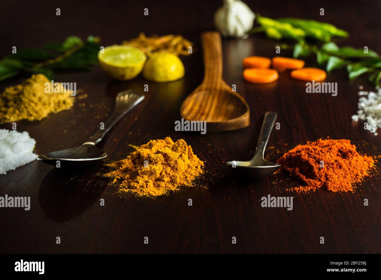 Les ingrédients de la nourriture magnifiquement garnie sur le dessus de table incluent diverses épices comme le froid, le citron, les feuilles de curry, le gingembre, l'ail, les crevettes, les cuillères etc Banque D'Images