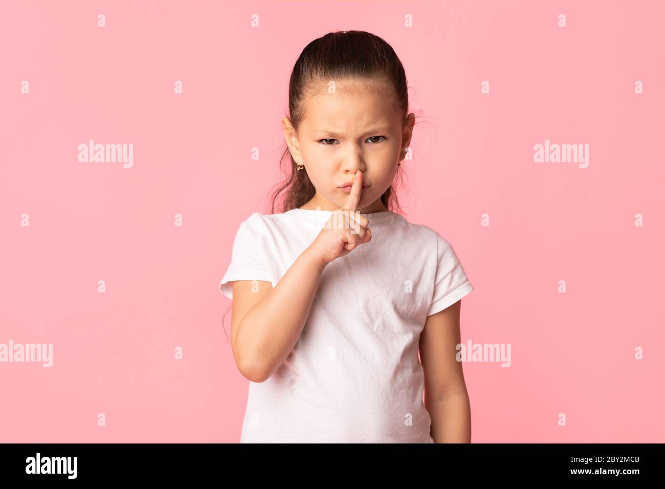 Drôle sérieuse asiatique fille puting doigt sur ses lèvres Banque D'Images