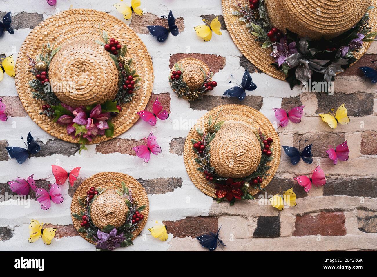 Chapeau d'été Fedora et arrangement coloré de fleurs séchées et de  papillons de décoration accrochée sur un mur de brique Photo Stock - Alamy