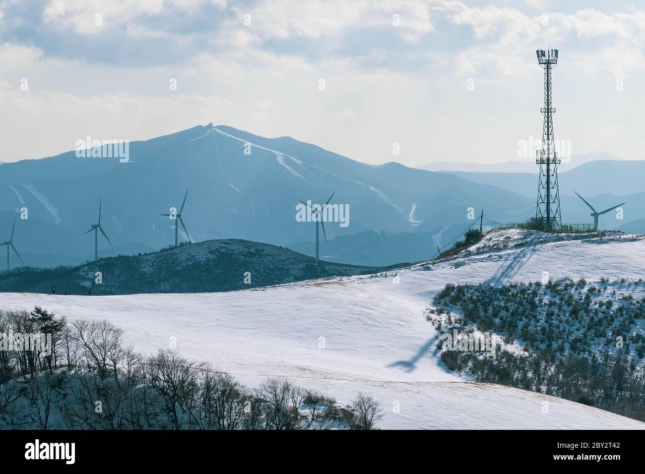 Moulin à turbine électrique sur un sol enneigé. Paysage de colline d'hiver avec ciel bleu avec de beaux nuages. Banque D'Images
