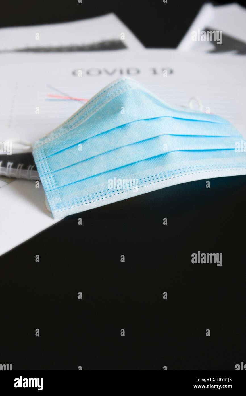 Fin de la pandémie du coronavirus et isolement. Masque médical bleu sur le graphique pour réduire l'incidence de la morbidité et de la mortalité. Concentrez-vous sur le masque Banque D'Images