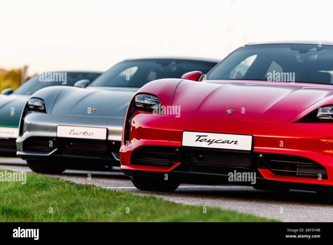 Alesund / Norvège - 31 mai 2020 : trois berlines Porsche Taycan de luxe dans un parking, garées à des fins promotionnelles. Gros plan avant. Banque D'Images