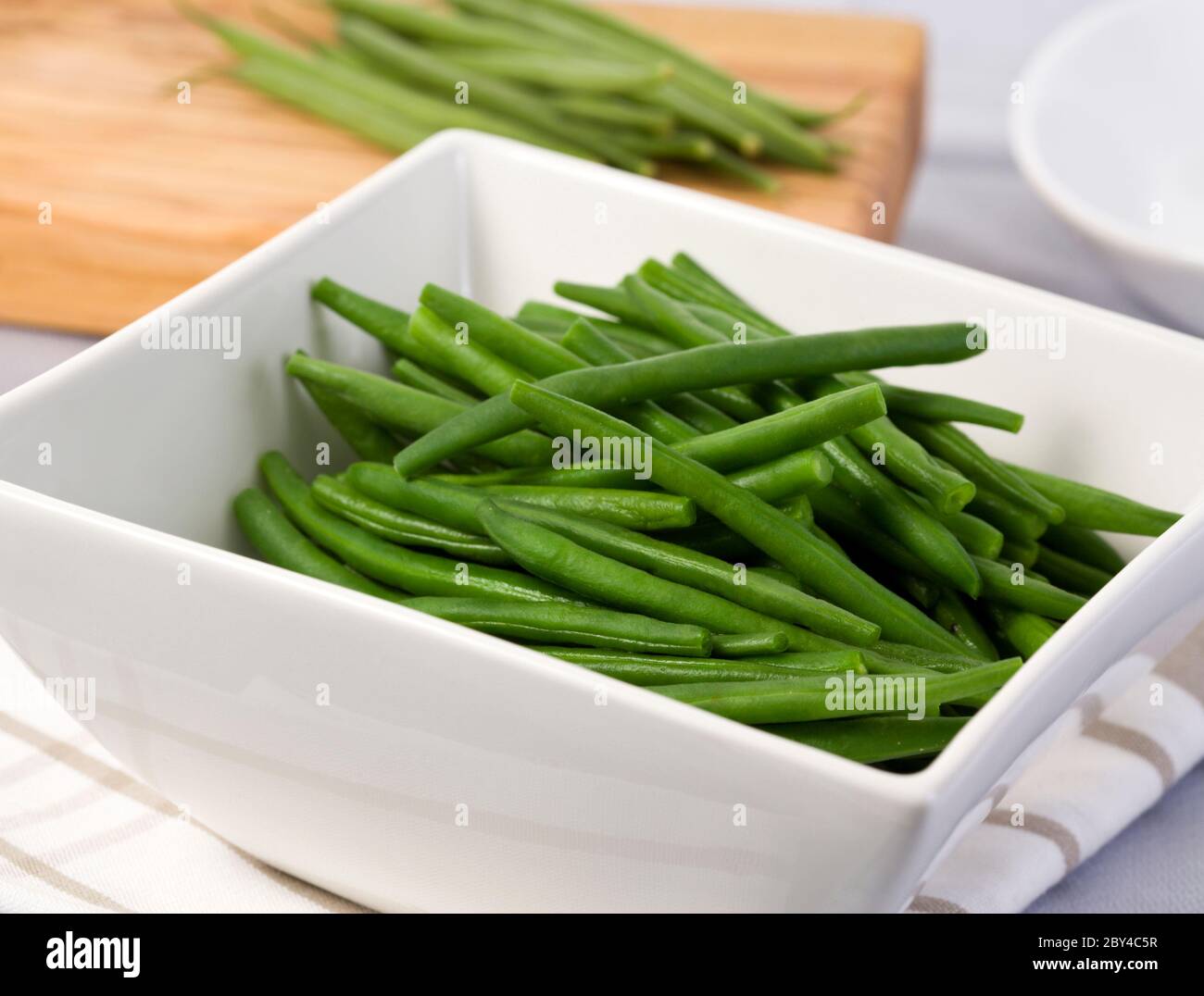 Faire étaier les haricots verts dans un bol carré blanc sur la table Banque D'Images