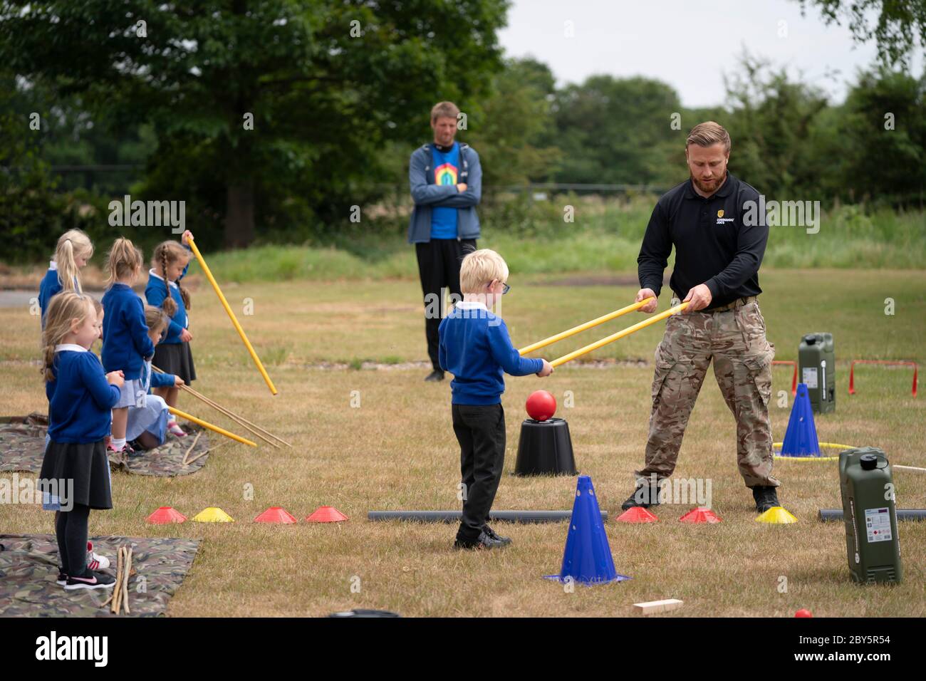 Staffordshire, Grande-Bretagne. 8 juin 2020. Accueil les élèves de l'école primaire de Landerwood utilisent des bâtons pour garder leur distance sociale tout en participant à un programme d'éducation de caractère de Commando Joe dirigé par Stu Wilkinson (1er R), à Staffordshire, en Grande-Bretagne, le 8 juin 2020. Le programme de commando Joe est un grand personnage et un service de développement et de soutien éducatif pour les écoles à travers le Royaume-Uni, inspirant les élèves avec des compétences de renforcement d'équipe, de caractère et de résilience. Il aide les élèves à faire face à la réintégration dans l'environnement de la salle de classe. Crédit : Jon Super/Xinhua/Alay Live News Banque D'Images