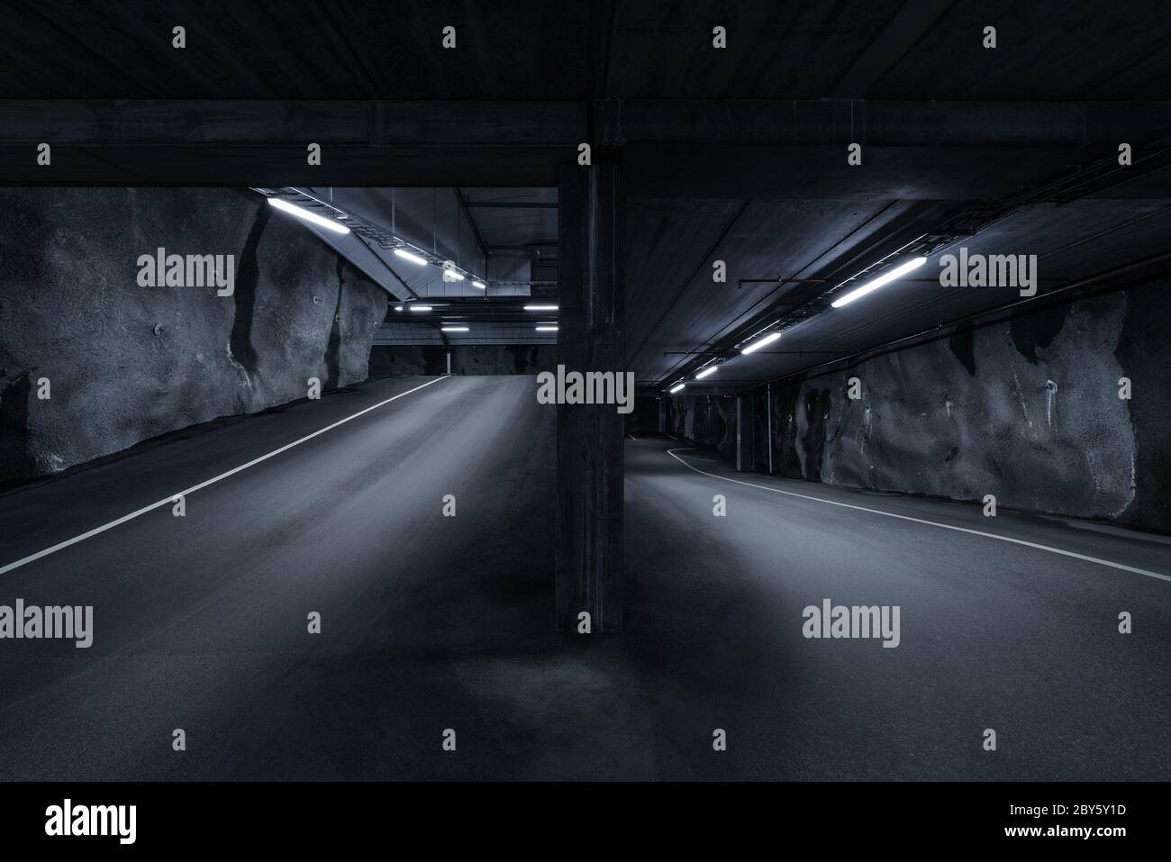 Parking souterrain de l'hôtel SCI fi, sombre et sombre, avec lumières fluorescentes allumées. Deux façons Banque D'Images