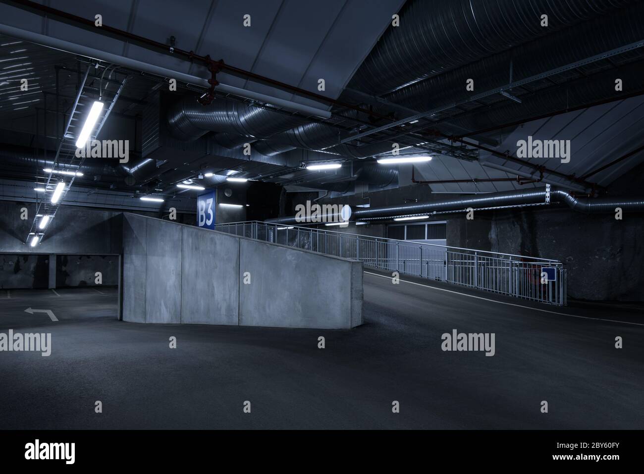 Parking souterrain de l'hôtel SCI fi, sombre et sombre, avec lumières fluorescentes allumées. Beaucoup de détails concrets. Banque D'Images