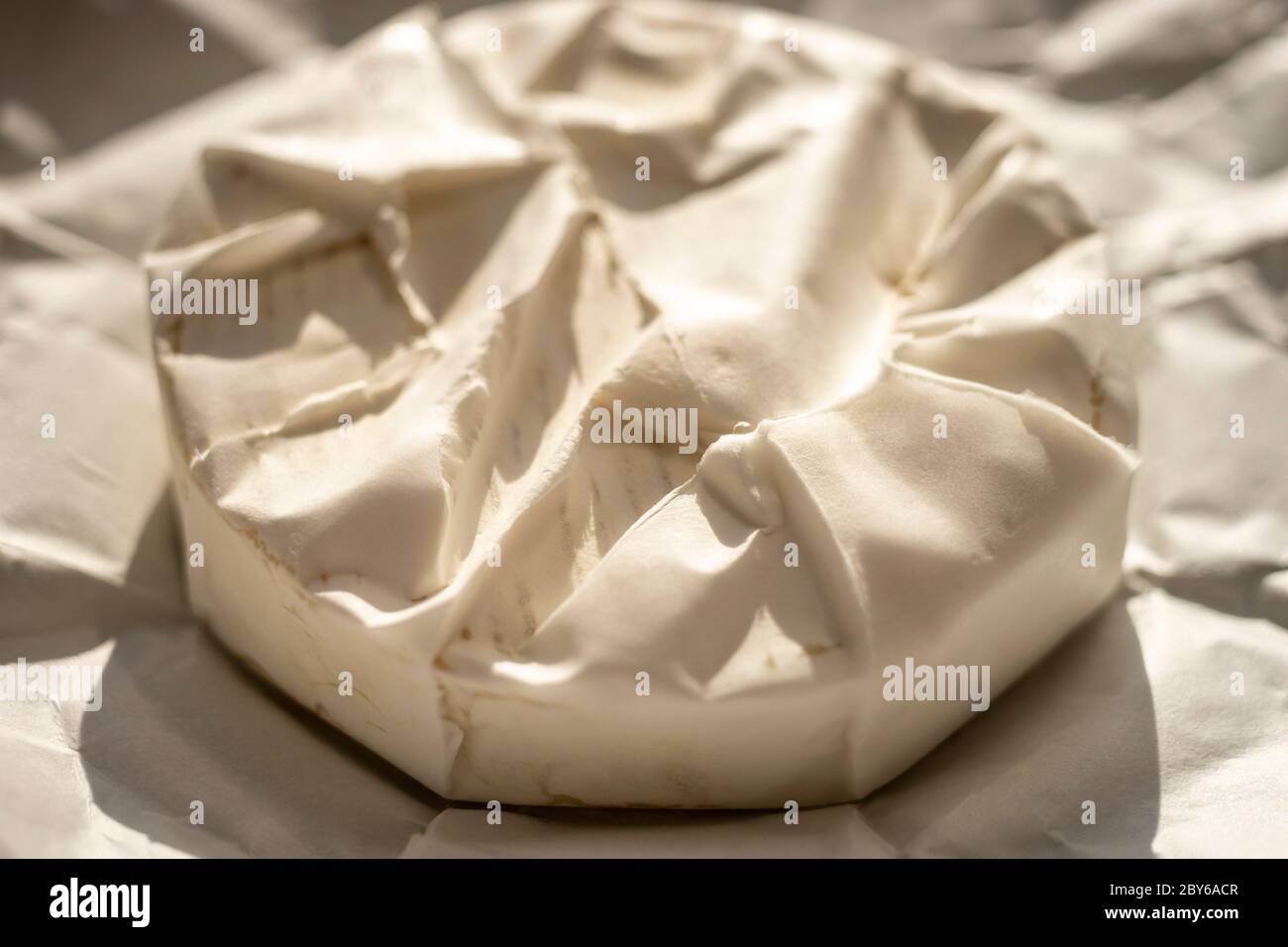 Fromage camembert rond entier dans papier d'emballage Banque D'Images