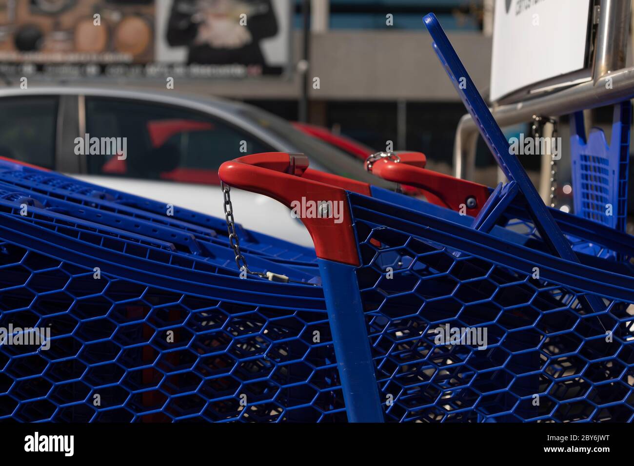 Les chariots, de couleur bleue et en plastique, sont rangés dans le parking extérieur d'un grand centre commercial, à Madrid. Banque D'Images
