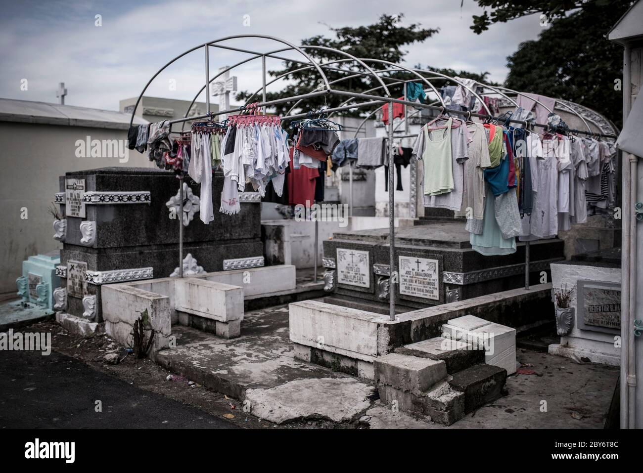 Certains lavoirs sont accroché à une structure sur certaines tombes du cimetière du nord de Manille, aux Philippines. À Manille, 2 des plus grands cimetières abritent des centaines de familles qui ont été expules de leurs maisons après la hausse des prix du logement. Banque D'Images