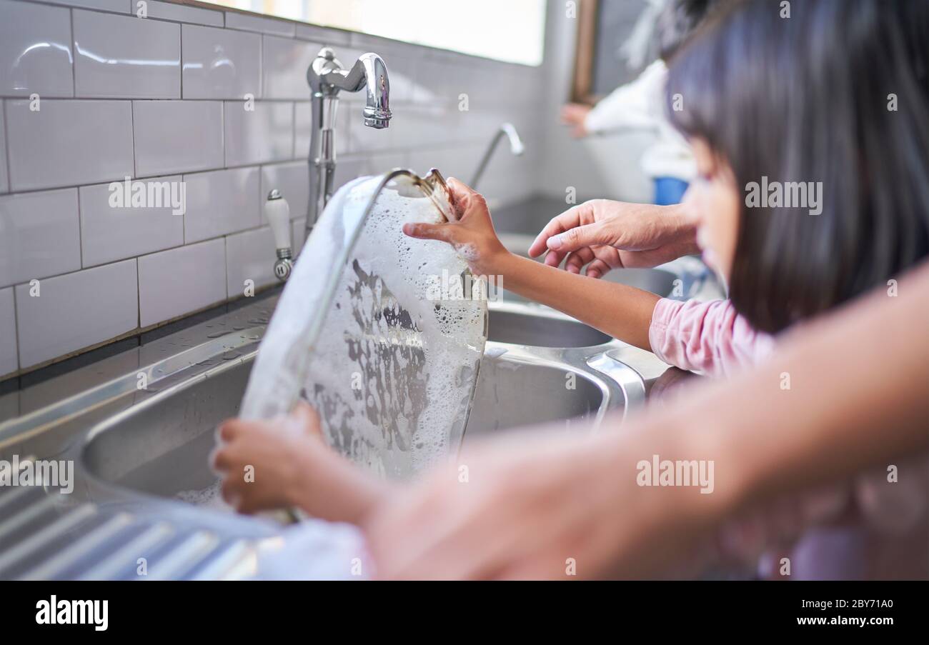 Vaisselle de cuisine à laver pour fille à l'évier de cuisine Banque D'Images